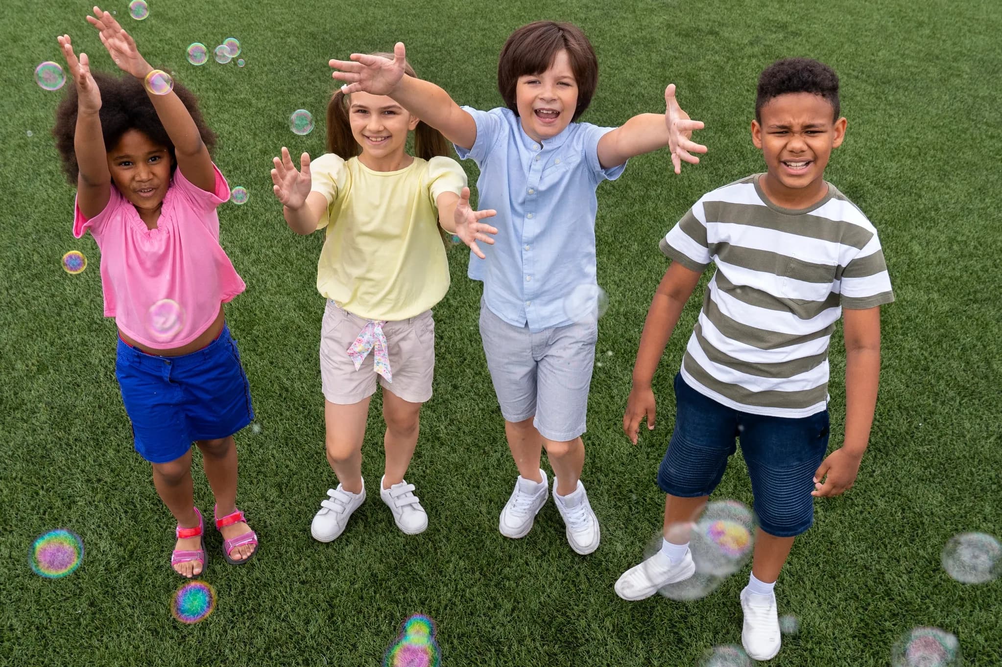 Niños jugando al aire libre entre burbujas